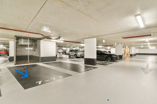 Een ruime, overdekte parkeerplaats in de parkeergarage van het Miles/Django-complex aan de Zuidas!